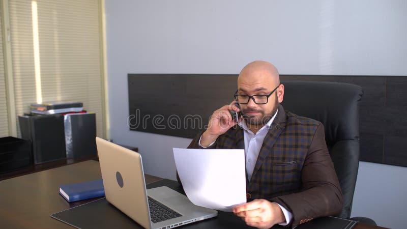 Geschäfts-, Leute-, Schreibarbeits- und Technologiekonzept - Geschäftsmann mit der Laptop-Computer und Papieren, die im Büro arbe