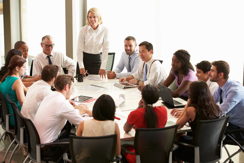 Geschäftsfrau-Addressing Meeting Around-Sitzungssaal-Tabelle lizenzfreie stockfotografie Geschäftsfrau-Addressing Meeting Around-Sitzungssaal-Tabelle lizenzfreie stockfotografie