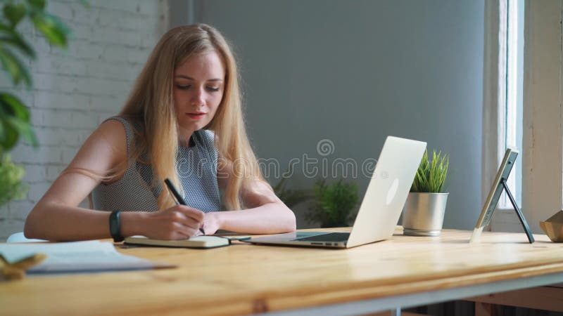 Geschäftsfrau am Arbeitsschreiben in einem Notizbuch