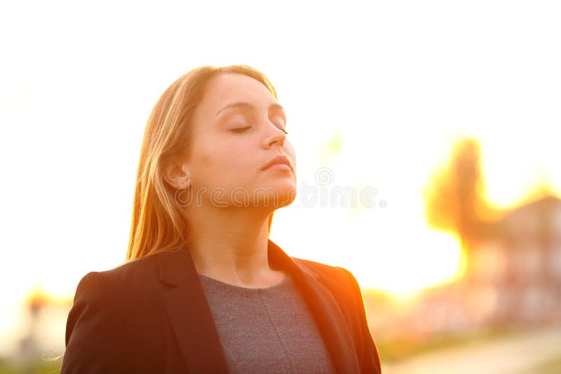 Serious businesswoman breathing fresh air at sunset standing outdoors. Serious businesswoman breathing fresh air at sunset standing outdoors