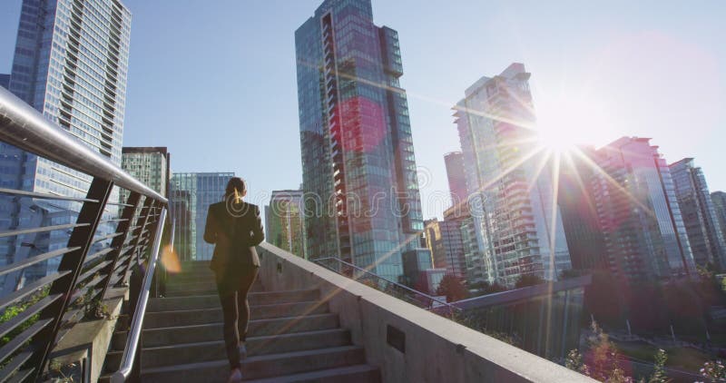 Geschäftsfrau, die draußen auf Treppe mit Smartphone und Kaffee in Vancouver geht