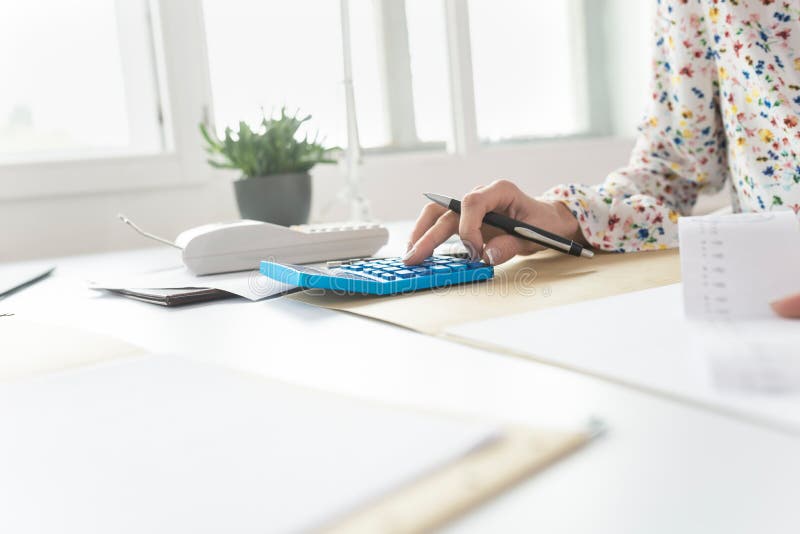 Geschäftsfrau, die eine Berechnung auf einem manuellen Tischrechner tut lizenzfreies stockbild Geschäftsfrau, die eine Berechnung auf einem manuellen Tischrechner tut lizenzfreies stockbild
