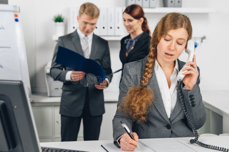Geschäftsfrau, die am Telefon im Büro spricht lizenzfreie stockfotos Geschäftsfrau, die am Telefon im Büro spricht lizenzfreie stockfotos