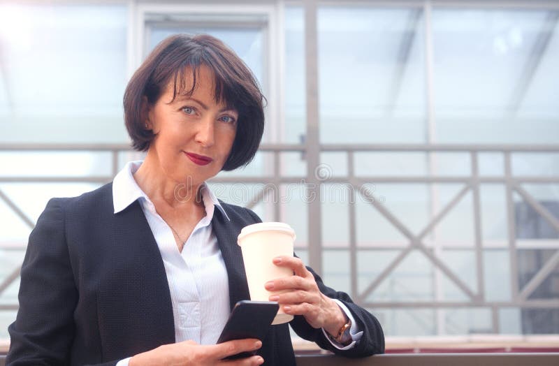 Geschäftsfrau, die vor einem Bürogebäude steht lizenzfreies stockbild Geschäftsfrau, die vor einem Bürogebäude steht lizenzfreies stockbild