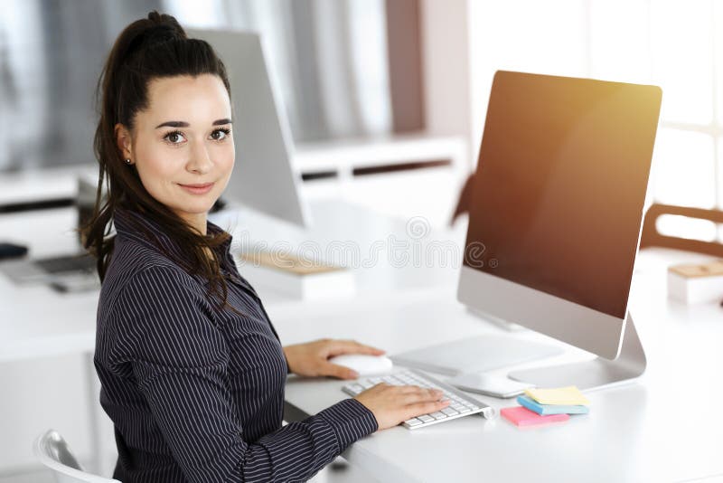Geschäftsfrau mit Computer am Arbeitsplatz in sonnigen Büro. Arbeit für Freude und Erfolg stockfotos