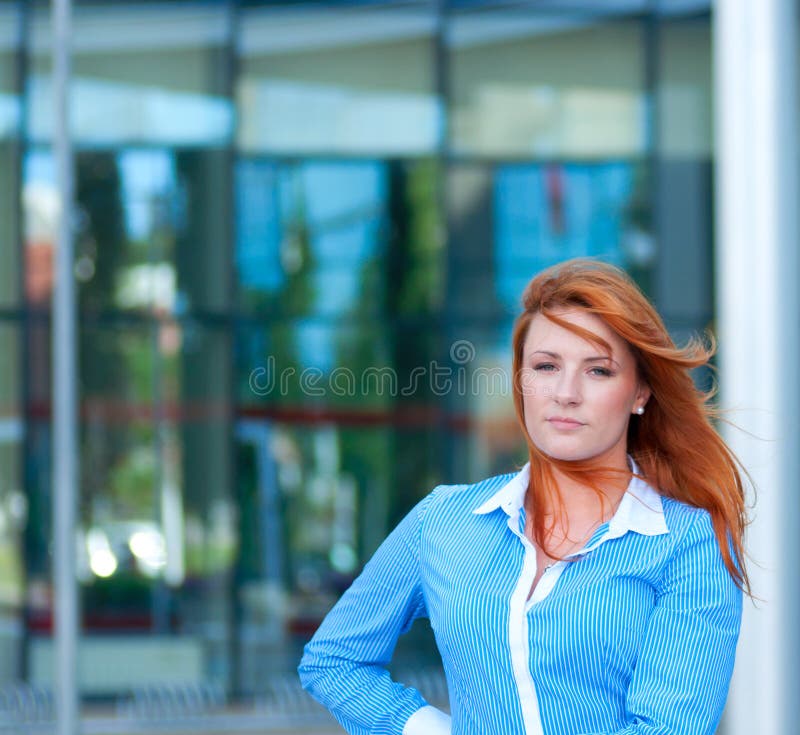 Geschäftsfrau mit dem roten Haar vor Bürogebäude. stockbild Geschäftsfrau mit dem roten Haar vor Bürogebäude. stockbild