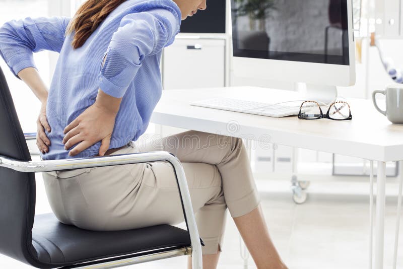 Geschäftsfrau mit Rückenschmerzen im Büro