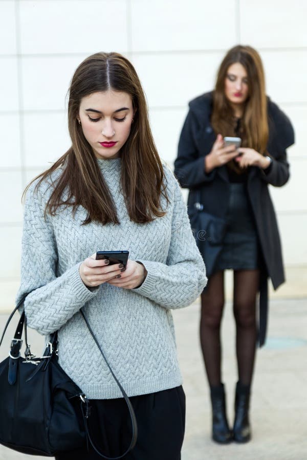 Geschäftsfrau mit zwei Jungen, die Handy in der Straße verwendet stockbilder Geschäftsfrau mit zwei Jungen, die Handy in der Straße verwendet stockbilder