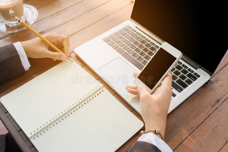 Geschäftsfrau schreiben auf Notizbuch und verwenden das Telefonarbeiten im Freien im Kaffeestubeweinleseton lizenzfreie stockfotos Geschäftsfrau schreiben auf Notizbuch und verwenden das Telefonarbeiten im Freien im Kaffeestubeweinleseton lizenzfreie stockfotos