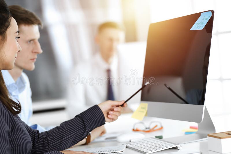 Geschäftsfrau und Mann diskutieren Fragen während der Verwendung von Computer am Arbeitsplatz in sonnigen Büro lizenzfreies stockbild