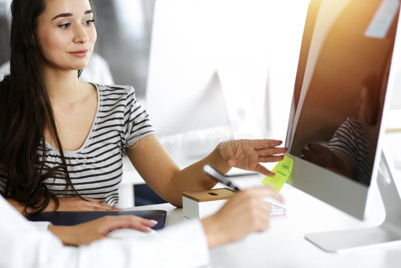 Geschäftsfrau und Mann diskutieren Fragen während der Verwendung von Computer am Arbeitsplatz in sonnigen Büro lizenzfreie stockfotos