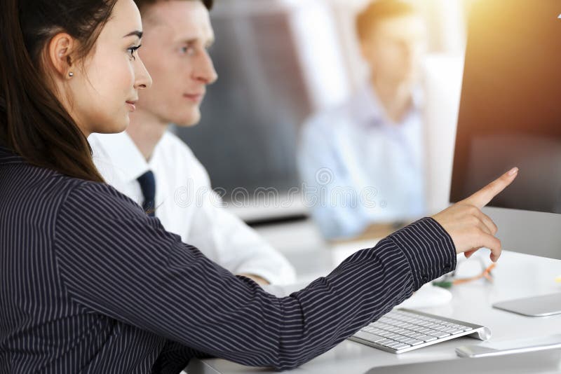 Geschäftsfrau und Mann diskutieren Fragen während der Verwendung von Computer am Arbeitsplatz in sonnigen Büro stockfoto