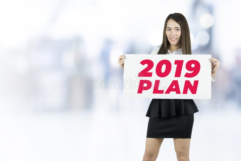 Geschäftsfrauholding beklebt das Zeichen mit 2019 Plänen mit Plakaten