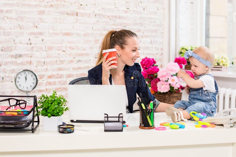 Geschäftsfraumutterfrau mit einer Tochter, die am Computer arbeitet stockfoto