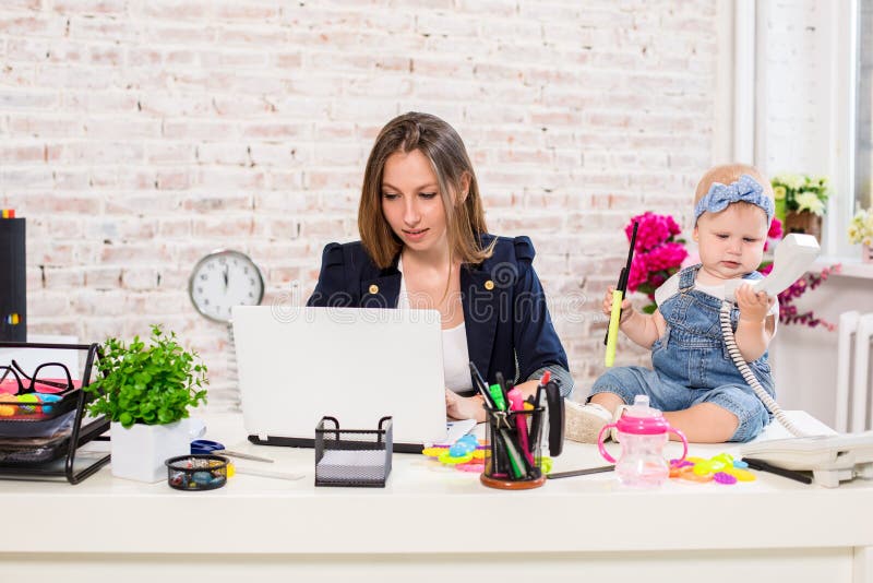 Geschäftsfraumutterfrau mit einer Tochter, die am Computer arbeitet stockfoto