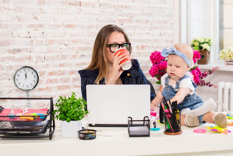 Geschäftsfraumutterfrau mit einer Tochter, die am Computer arbeitet stockbild