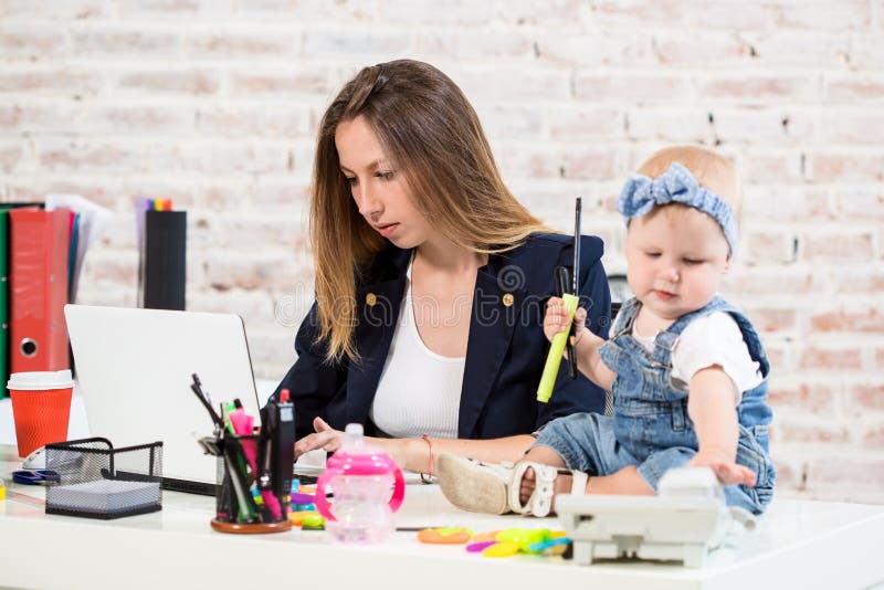 Geschäftsfraumutterfrau mit einer Tochter, die am Computer arbeitet lizenzfreie stockfotografie