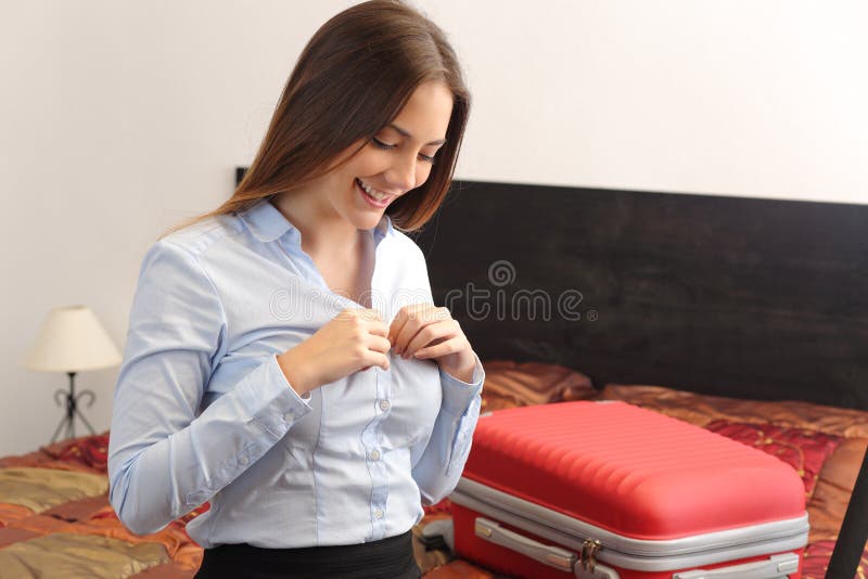 Geschäftsfraureisender, der in einem Hotelzimmer sich auszieht stockbild Geschäftsfraureisender, der in einem Hotelzimmer sich auszieht stockbild