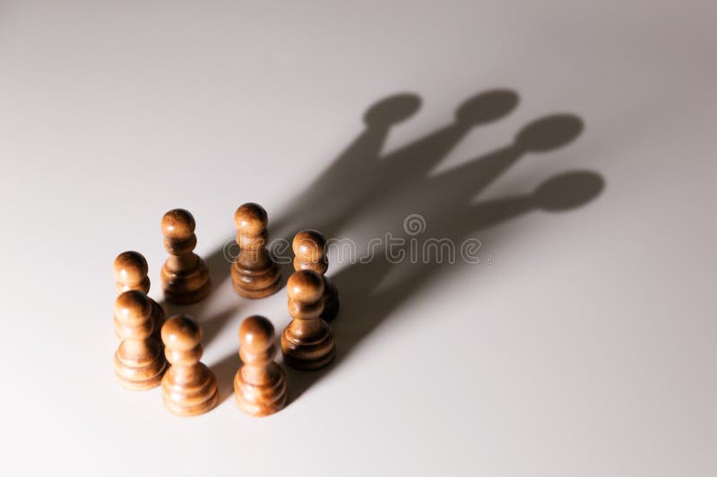 Business leadership, teamwork power and confidence concept. chess pawns with king shadow. Business leadership, teamwork power and confidence concept. chess pawns with king shadow