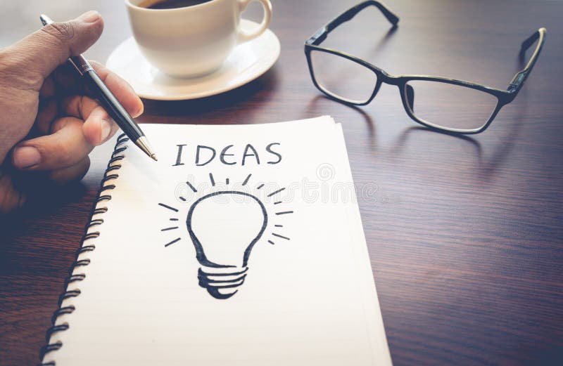 Business creativity concepts ideas.light bulb drawing on notepad.working in the morning with coffee cup.idea coming. Business creativity concepts ideas.light bulb drawing on notepad.working in the morning with coffee cup.idea coming.