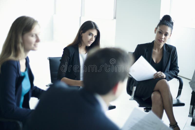 Geschäftsleute, die in einem Geschäftstreffen sitzen lizenzfreie stockfotos Geschäftsleute, die in einem Geschäftstreffen sitzen lizenzfreie stockfotos