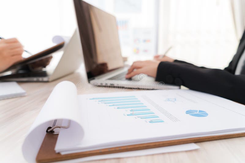 Geschäftsleute, die Laptop und Finanzdiagramme am Treffen von O verwenden stockfoto Geschäftsleute, die Laptop und Finanzdiagramme am Treffen von O verwenden stockfoto