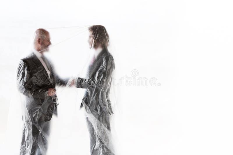 Geschäftsleute, die mit Plastik die Hände schütteln, um sich vor dem Coronavirus zu schützen lizenzfreies stockfoto Geschäftsleute, die mit Plastik die Hände schütteln, um sich vor dem Coronavirus zu schützen lizenzfreies stockfoto