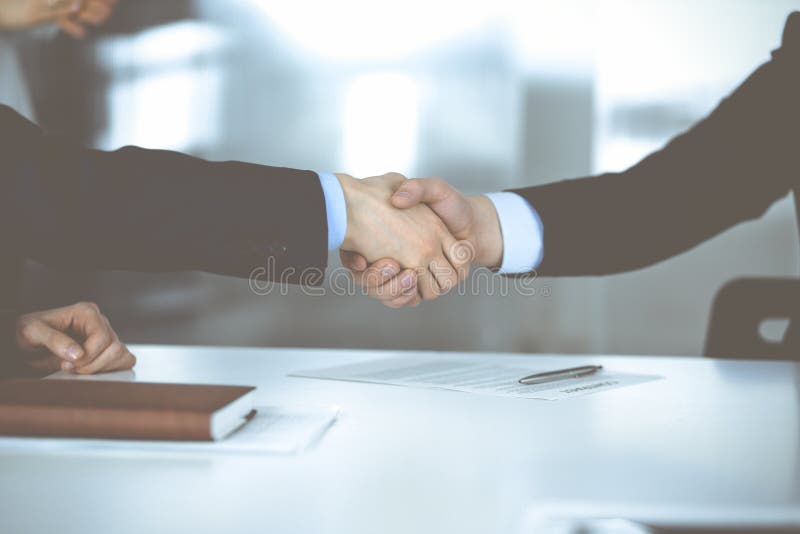 Geschäftsleute, die sich bei Besprechungen oder Verhandlungen die Hand schütteln. Gruppe von unbekannten Geschäftsleuten und einer lizenzfreies stockfoto