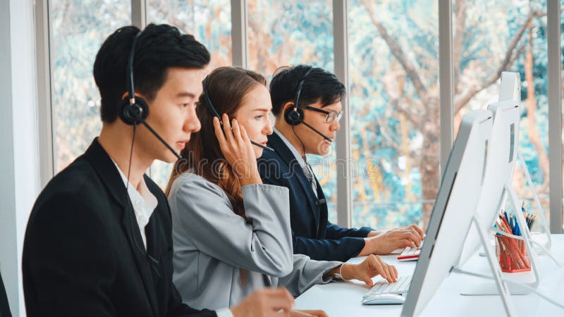 Geschäftsleute mit Headset, die im Büro arbeiten stockfotografie