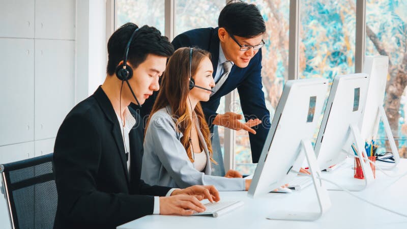 Geschäftsleute mit Headset, die im Büro arbeiten lizenzfreie stockfotografie
