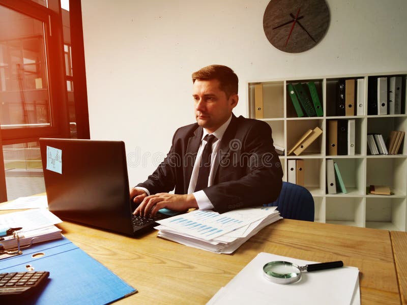 Geschäftsmann arbeitet am Computer im Büro Ein Mann tippt auf einen Laptop lizenzfreie stockfotografie