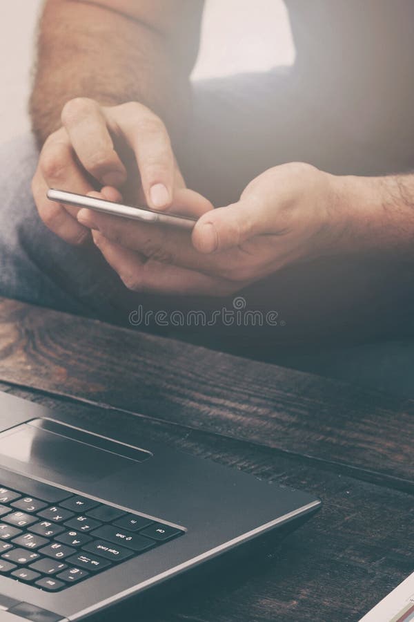 Geschäftsmann Arbeitslaptop und Smartphone auf dem Sofa zu Hause stockfotografie Geschäftsmann Arbeitslaptop und Smartphone auf dem Sofa zu Hause stockfotografie