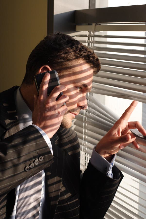 Geschäftsmann auf dem Telefonschauen stockbild Geschäftsmann auf dem Telefonschauen stockbild