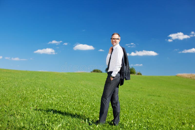 Geschäftsmann, der auf einem grünen Gebiet steht stockbild Geschäftsmann, der auf einem grünen Gebiet steht stockbild