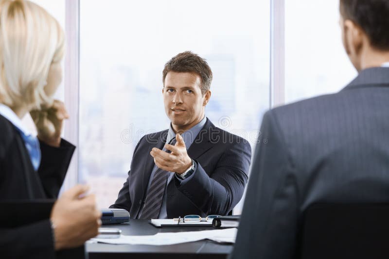 Geschäftsmann, der bei der Sitzung spricht lizenzfreies stockbild Geschäftsmann, der bei der Sitzung spricht lizenzfreies stockbild