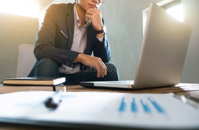 Geschäftsmann, der an Geschäftsdokument und Laptop an einem Arbeitsplatz arbeitet stockfotos Geschäftsmann, der an Geschäftsdokument und Laptop an einem Arbeitsplatz arbeitet stockfotos