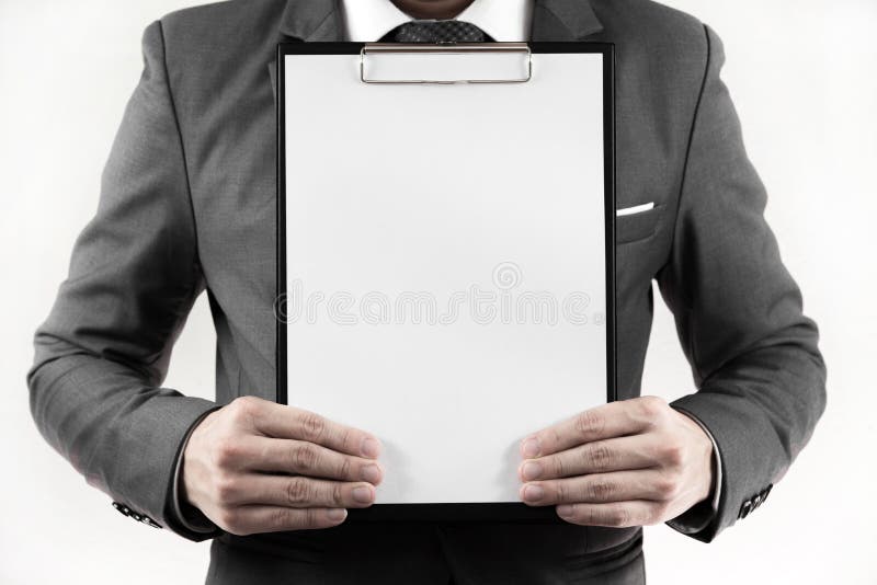 Geschäftsmann in der Klage, die ein leeres Klemmbrett hält stockbild