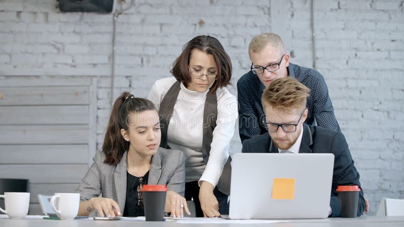 Geschäftsmann, der Laptop verwendet und Projekt mit Angestelltem MA bespricht