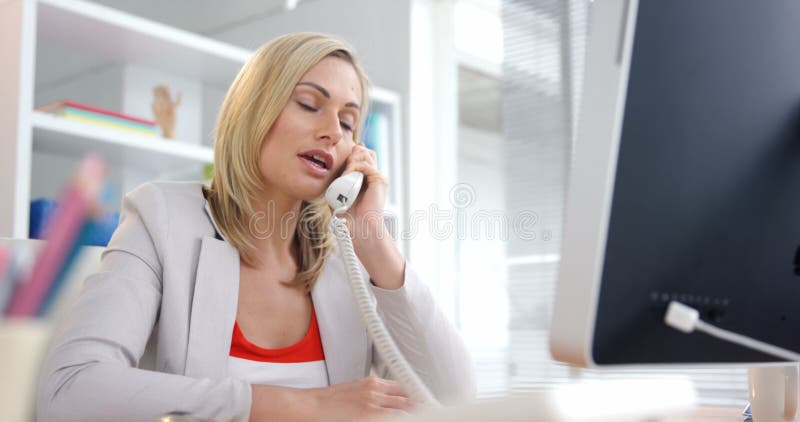 Geschäftsmann, der am Telefon spricht und an Computer arbeitet