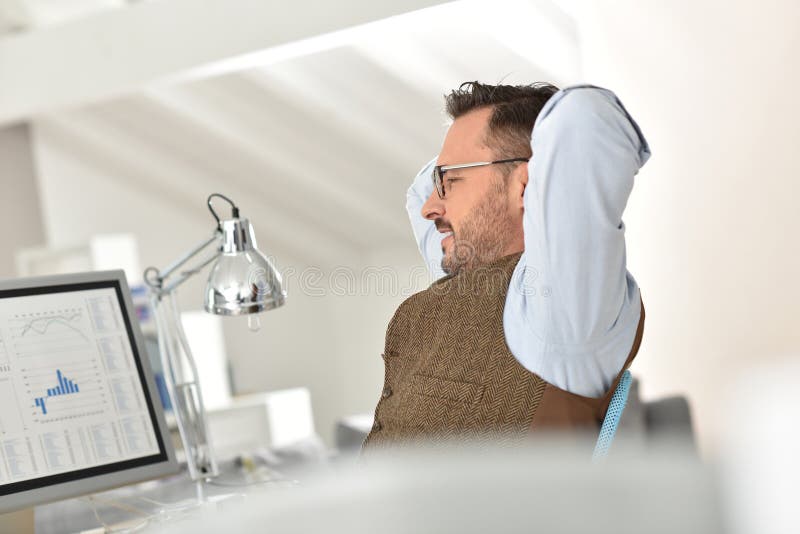 Geschäftsmann mit Brillen im Büro, das einen Bruch hat lizenzfreies stockfoto Geschäftsmann mit Brillen im Büro, das einen Bruch hat lizenzfreies stockfoto