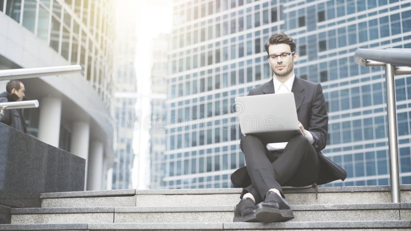 Geschäftsmann mit einem Laptop, der im Freien arbeitet stockbild Geschäftsmann mit einem Laptop, der im Freien arbeitet stockbild