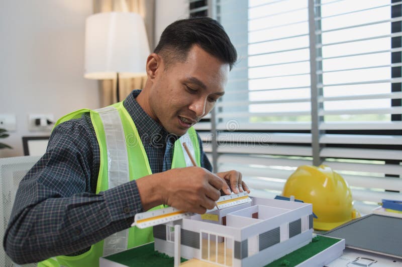Geschäftsmann oder Architekt mit Modell eines Hauses, der in Büroarchitekten arbeitet und mit Planen Ingenieur inspect arbeitet stockfoto