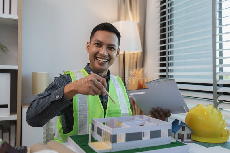Geschäftsmann oder Architekt mit Modell eines Hauses, der in Büroarchitekten arbeitet und mit Planen Ingenieur inspect arbeitet stockbild