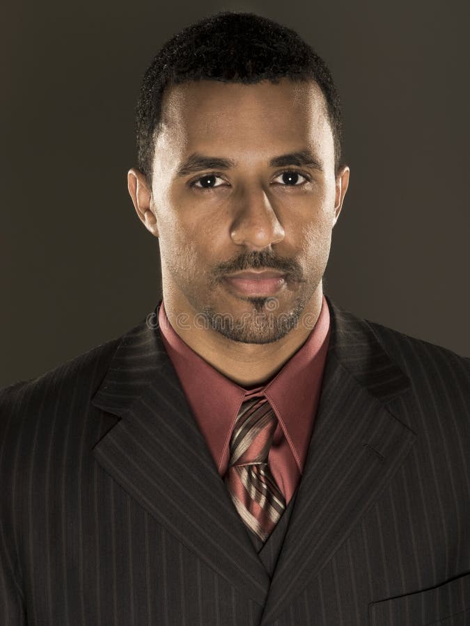 Studio portrait of a smartly dressed African American businessman looking at the camera. Studio portrait of a smartly dressed African American businessman looking at the camera.