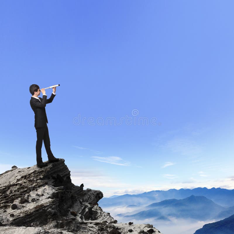 Geschäftsmann schaut durch Teleskop auf Berg lizenzfreies stockbild Geschäftsmann schaut durch Teleskop auf Berg lizenzfreies stockbild