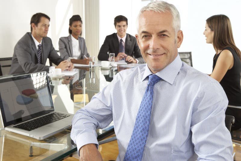 Geschäftsmann-Sitting Around Boardroom-Tabelle mit Kollegen stockbild Geschäftsmann-Sitting Around Boardroom-Tabelle mit Kollegen stockbild