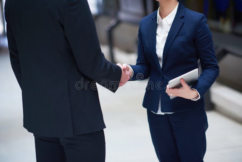 Geschäftsmann- und Frauenhanderschütterung lizenzfreies stockbild Geschäftsmann- und Frauenhanderschütterung lizenzfreies stockbild