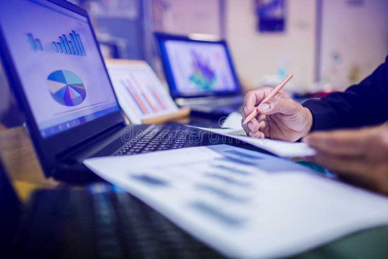 Geschäftsmannhand, die an Laptop-Computer mit Geschäftsdiagramm-Informationsdiagramm auf hölzernem Schreibtisch arbeitet lizenzfreie stockfotografie Geschäftsmannhand, die an Laptop-Computer mit Geschäftsdiagramm-Informationsdiagramm auf hölzernem Schreibtisch arbeitet lizenzfreie stockfotografie