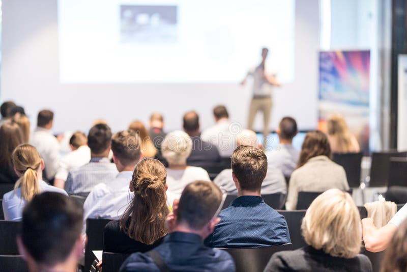 Speaker giving a talk in conference hall at business event. Audience at the conference hall. Business and Entrepreneurship concept. Focus on unrecognizable people in audience. Speaker giving a talk in conference hall at business event. Audience at the conference hall. Business and Entrepreneurship concept. Focus on unrecognizable people in audience.