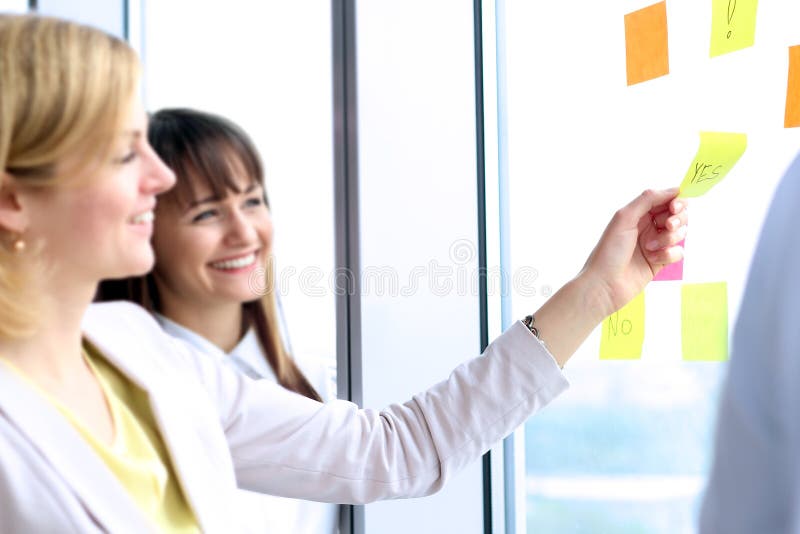 Geschäftsteam, das mit digitaler Tablette und Aufklebern im Büro arbeitet lizenzfreies stockbild Geschäftsteam, das mit digitaler Tablette und Aufklebern im Büro arbeitet lizenzfreies stockbild